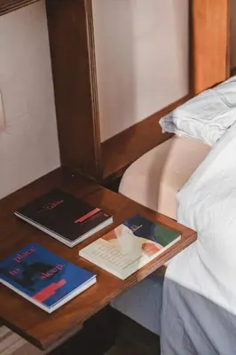 a wooden table with books on it next to a bed at Your colourful Antwerp Oasis in Antwerp