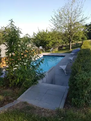 a swimming pool with two lounge chairs next to it at Vakantiewoning De Woestijn - De Schuur in Roosdaal