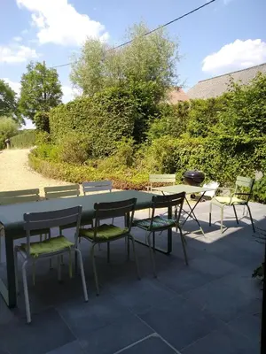 a table and chairs sitting on a patio at Vakantiewoning De Woestijn - De Schuur in Roosdaal