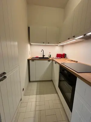 a kitchen with white cabinets and a sink at Studio Winston Churchill in Brussels