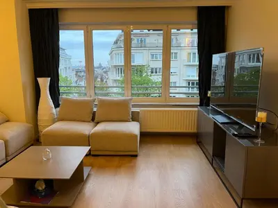 a living room with a couch and a large window at Studio Winston Churchill in Brussels
