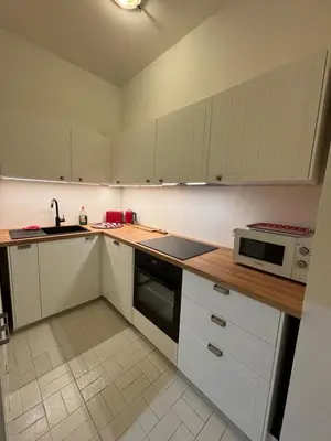 a kitchen with white cabinets and a sink and a microwave at Studio Winston Churchill in Brussels