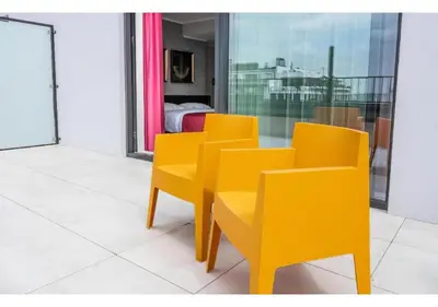 a group of yellow chairs and a table in a room at Hotel Jamingo in Antwerp