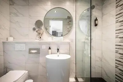 a white bathroom with a sink and a mirror at Hotel Jamingo in Antwerp