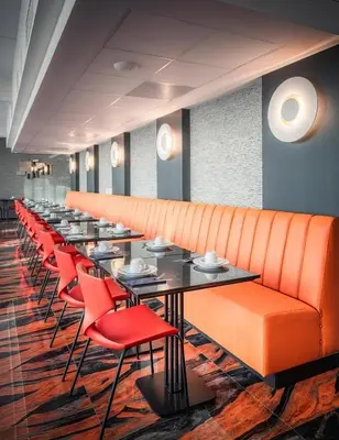 a long dining room with red chairs and tables at Hotel Jamingo in Antwerp