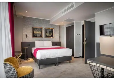 a hotel room with a bed and a chair at Hotel Jamingo in Antwerp