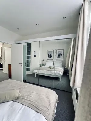 a bedroom with two beds and a large mirror at Magnifique appartement au coeur du SABLON ! in Brussels