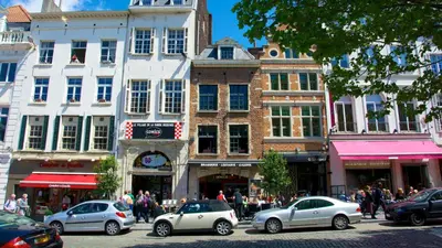 a busy city street with cars parked in front of buildings at Magnifique appartement au coeur du SABLON ! in Brussels