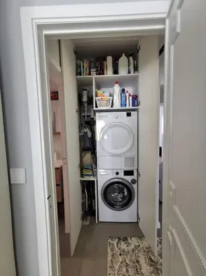 a laundry room with a washing machine in a hallway at European heart 2-bedroom flat. in Brussels