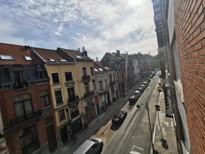 a view of a city street with cars parked on the street at European heart 2-bedroom flat. in Brussels