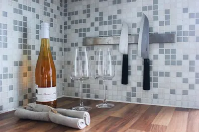 a bottle of wine and two wine glasses on a wall at Sunny Apartment - Zuid Retreat 1BR Apartment near Scheldt River in Antwerp