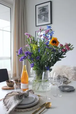 a table with a vase of flowers on it at Sunny Apartment - Zuid Retreat 1BR Apartment near Scheldt River in Antwerp