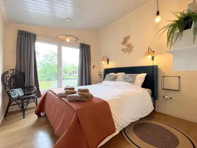 a bedroom with a large bed and a window at Charlies Chalet in Geel