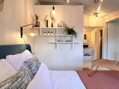 a bedroom with a bed and a table and shelves at Charlies Chalet in Geel