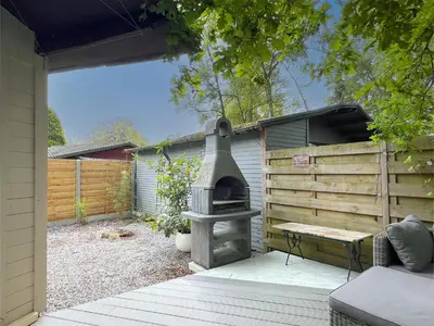 a patio with an outdoor oven in a backyard at Charlies Chalet in Geel