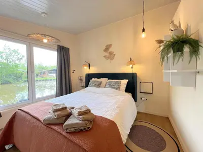 a bedroom with a large bed with towels on it at Charlies Chalet in Geel
