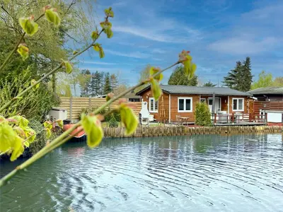a house on the water with a house at Fonnies Chalet in Geel