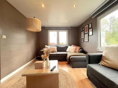 a living room with a couch and a table at Fonnies Chalet in Geel