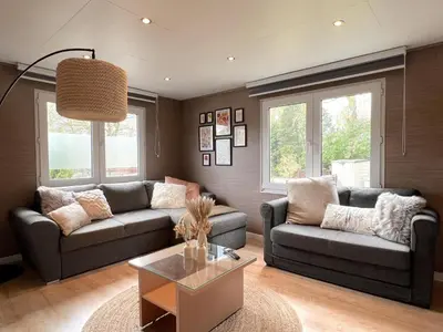a living room with two couches and a table at Fonnies Chalet in Geel