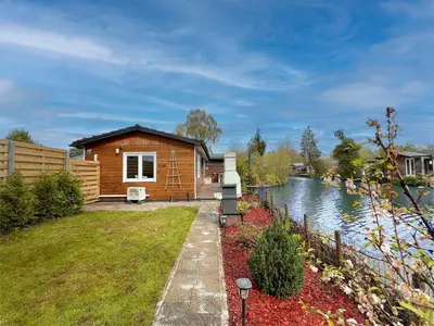 a log cabin next to a river at Fonnies Chalet in Geel