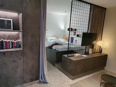 a bedroom with a bed and a mirror at Suite Erasmus in Sint-Pieters-Leeuw