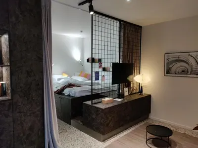 a bedroom with a bed and a large mirror at Suite Erasmus in Sint-Pieters-Leeuw