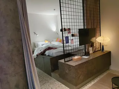 a bedroom with a bed and a mirror at Suite Erasmus in Sint-Pieters-Leeuw