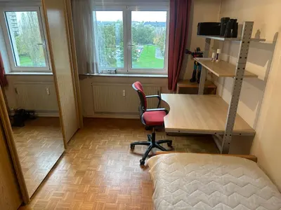 a room with a desk and a chair and windows at Résidence Europe in Brussels