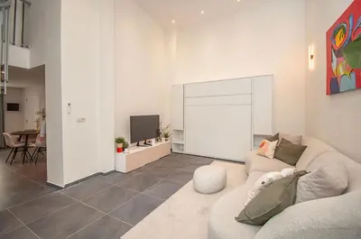 a living room with a couch and a tv at Loft in Antwerp City Centre in Antwerp