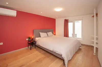 a bedroom with a red wall and a bed at Loft in Antwerp City Centre in Antwerp