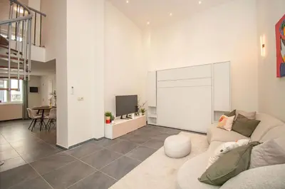 a living room with a couch and a tv at Loft in Antwerp City Centre in Antwerp