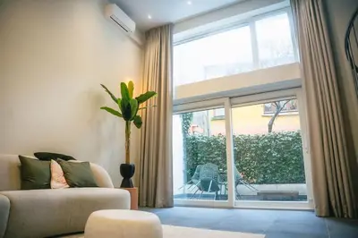 a living room with a couch and a large window at Loft in Antwerp City Centre in Antwerp