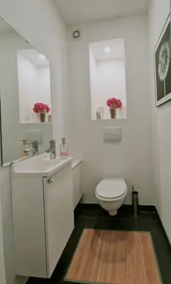 a white bathroom with a toilet and a sink at Le cocon du midi - Appartement Cosy in Brussels