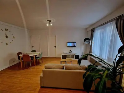 a living room with a couch and a table at Le cocon du midi - Appartement Cosy in Brussels