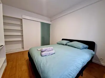 a bedroom with a large bed with two pillows on it at Le cocon du midi - Appartement Cosy in Brussels