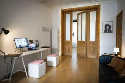 a living room with a desk with a computer on it at Grand appartement d'artiste cosy et proche de tout in Brussels