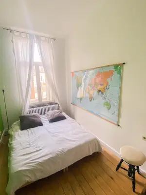 a bedroom with a bed with a map on the wall at Grand appartement d'artiste cosy et proche de tout in Brussels