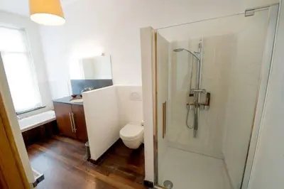 a bathroom with a shower and a toilet and a sink at Grand appartement d'artiste cosy et proche de tout in Brussels