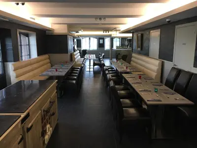 a row of tables and chairs in a restaurant at Hotel La Chaumiere in Asse