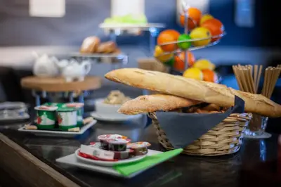 a table topped with a basket of bread and snacks at Hotel La Chaumiere in Asse
