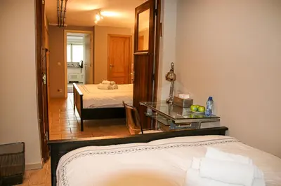a bedroom with a bed and a table and a mirror at Archimede Guest House in Brussels