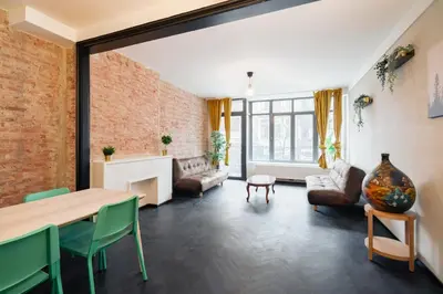 a living room with a brick wall and a table and chairs at Charming and Spacious Apartments in the Heart of Antwerp in Antwerp