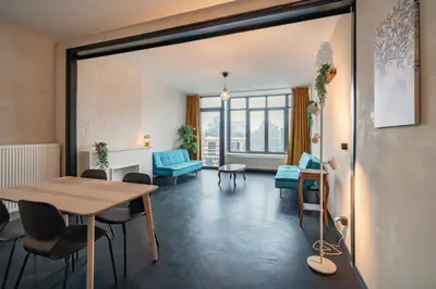 a living room with a table and chairs at Charming and Spacious Apartments in the Heart of Antwerp in Antwerp