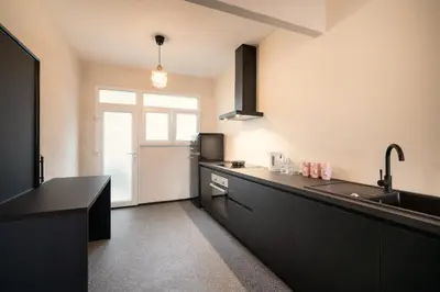 a kitchen with black cabinets and a black counter top at Charming and Spacious Apartments in the Heart of Antwerp in Antwerp