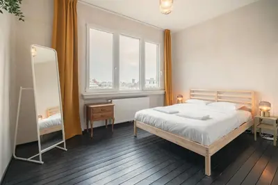 a bedroom with a bed and a large window at Charming and Spacious Apartments in the Heart of Antwerp in Antwerp
