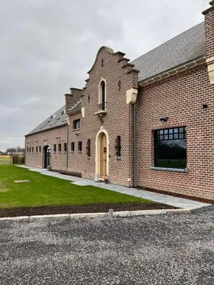 a large brick building with a yellow door at B&B Schaliëndak in Kortenberg