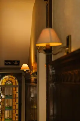 a lamp next to a wall with a window at Hotel Kempenrust in Kasterlee
