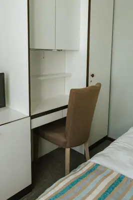 a bedroom with a desk and a chair next to a bed at Hotel Kempenrust in Kasterlee