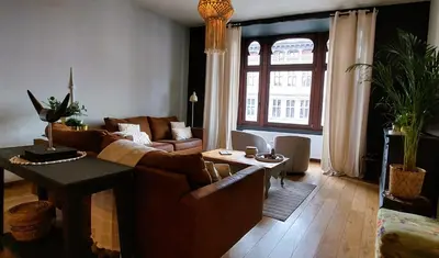a living room with a couch and a table at Diamond - room with a view in Antwerp