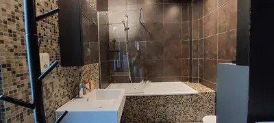 a bathroom with a shower with a tub and a sink at Diamond - room with a view in Antwerp